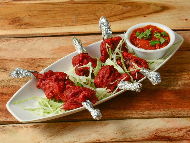 Chicken lollipop is indian chinese appetizer served over a\
wooden rustic background selective focus