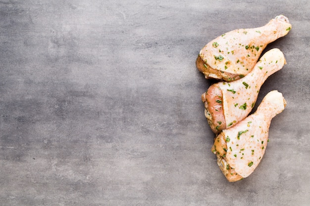 Chicken marinade legs, fresh vegetables on a gray background.Top view.