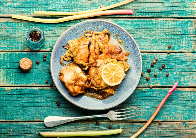 Foto carne di pollo al forno con rabarbaro, tavola di legno