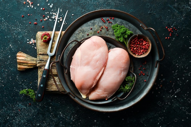 Chicken meat Raw fresh chicken breast on black slate stone background Top view Raw meat