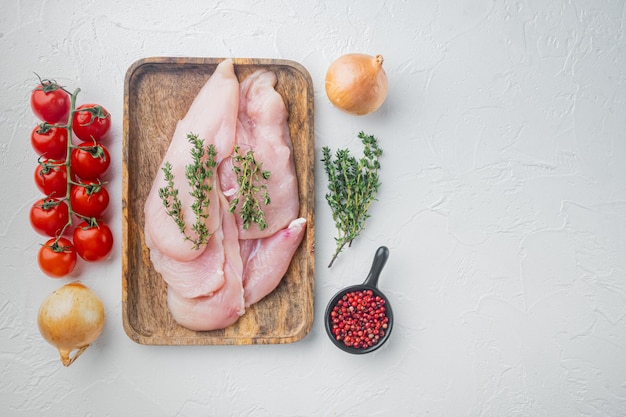 Chicken meat slices uncooked, on white background, top view flat lay with copy space for text