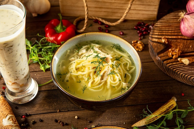 Zuppa di noodle e dovga di pollo sulla tavola di legno