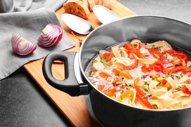 Chicken noodle soup in saucepan on kitchen table