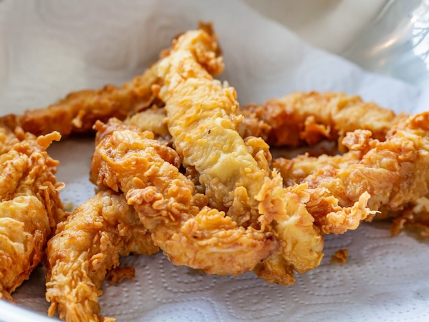 Chicken nuggets are laid out on a napkin to remove excess oil after frying