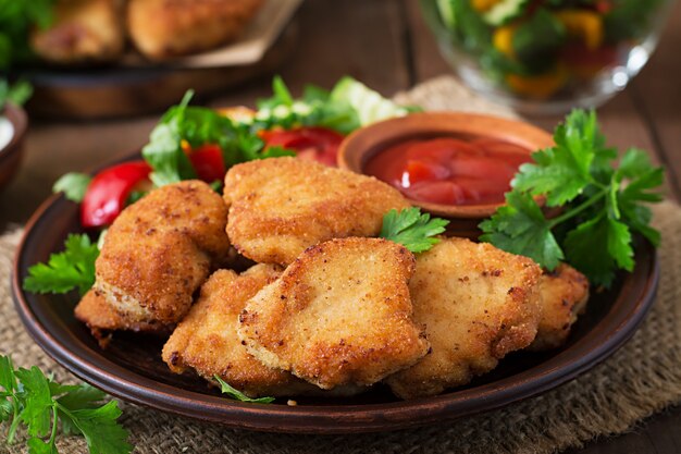 Chicken nuggets and sauce on a wooden table