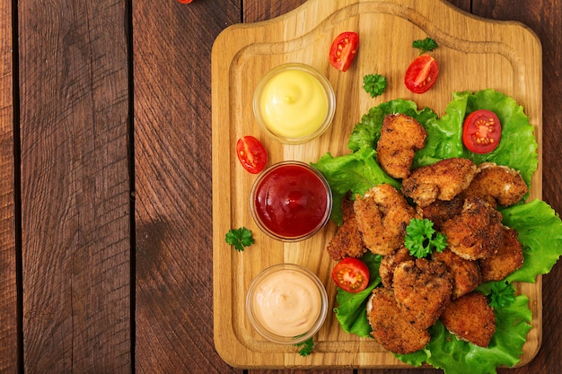 Chicken nuggets and sauce on a wooden table