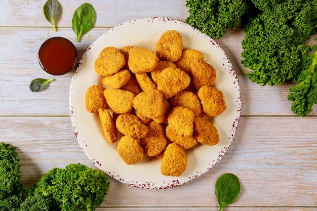 Photo chicken nuggets with ketchup on wooden table.