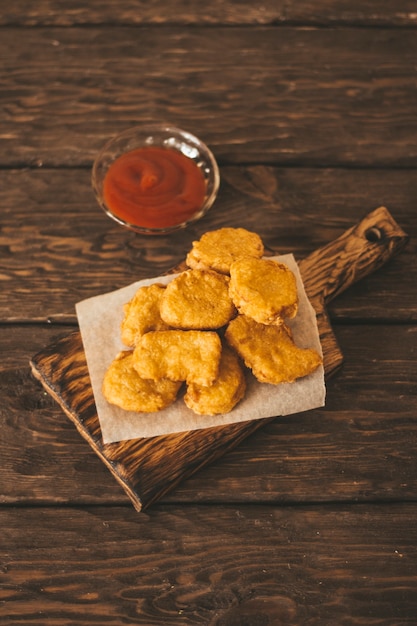 木製の背景にチキンナゲット