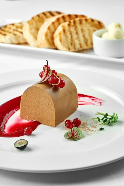 Chicken pate with cranberries croutons and butter on a white plate on a white plate Closeup Selective focus