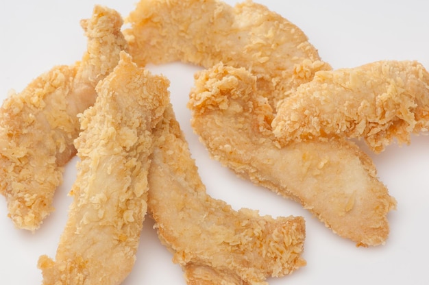 Chicken pieces in bread crumbs close up on a white background