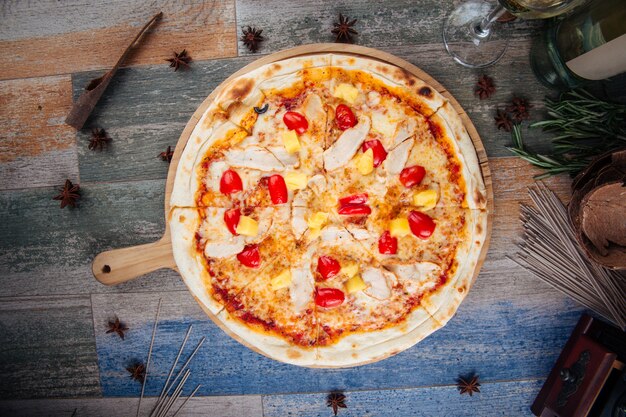 Chicken and pineapple pizza with cherry tomatoes