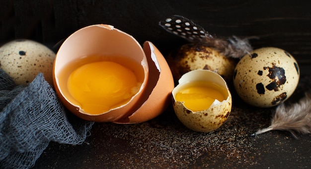 Chicken and quail eggs in a box on a dark background