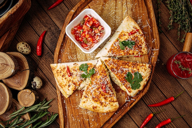 Chicken quesadilla with salsa sauce on serving board