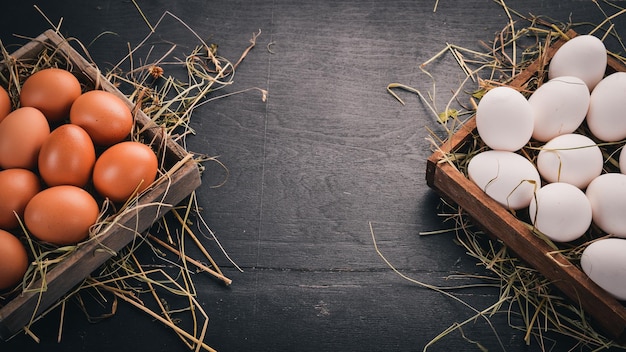 Chicken raw eggs in a wooden basket On a wooden background Top view Copy space