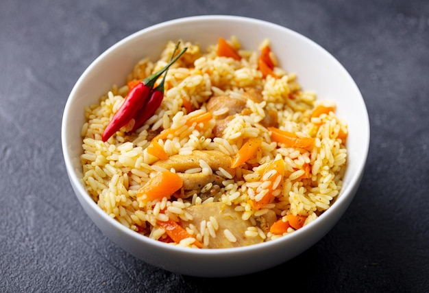 Chicken and rice pilaf plov on white bowl Grey background Close up