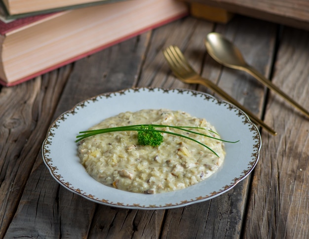 Chicken risotto served in a dish isolated on wooden background side view