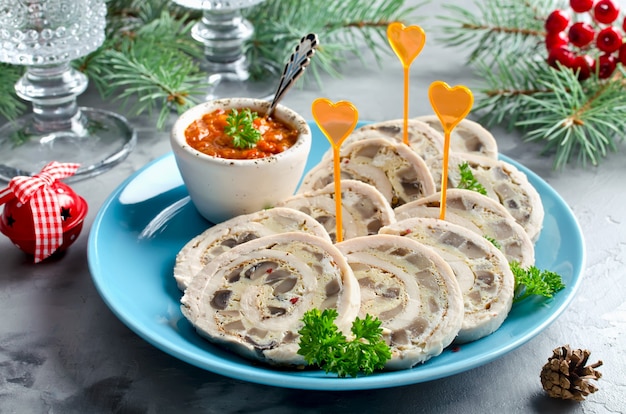 Foto rotolo di pollo (involtino) con frittata (frittata) e funghi. antipasto di capodanno