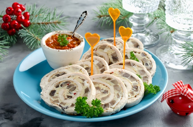 Foto rotolo di pollo (involtino) con frittata (frittata) e funghi. antipasto di capodanno