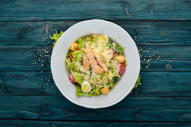 Chicken Salad and Fresh Vegetables Caesar Top view On a blue wooden background Copy space