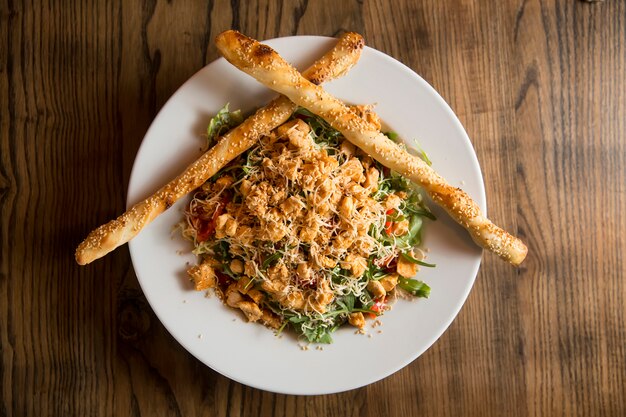 Chicken salad with rocket, cherry tomatoes, smoked cheese and crunchy sesame sticks