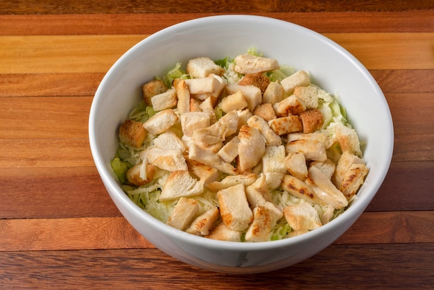 Chicken salad with vegetables in a white bowl.