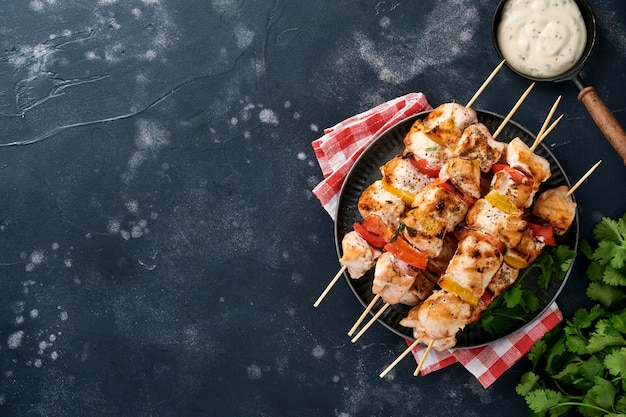 Photo chicken shish kebab or skewers kebab on wooden board, spices, herbs vegetables