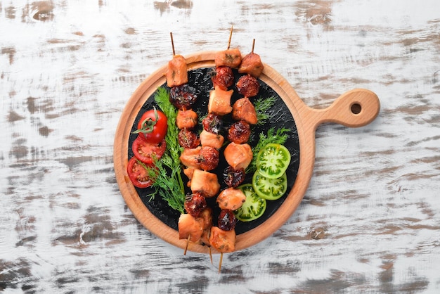 Chicken shish kebab with cherry tomatoes on a white wooden background Meat Top view Free copy space