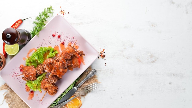 Chicken shish kebab with sesame seeds and barbecue sauce On a wooden background Top view Free space for your text