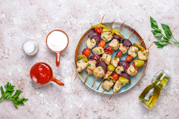 Chicken shish kebab with vegetables,ketchup,mayonnaise,top view