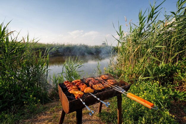 Chicken skewers are fried on skewers and a grilled grate