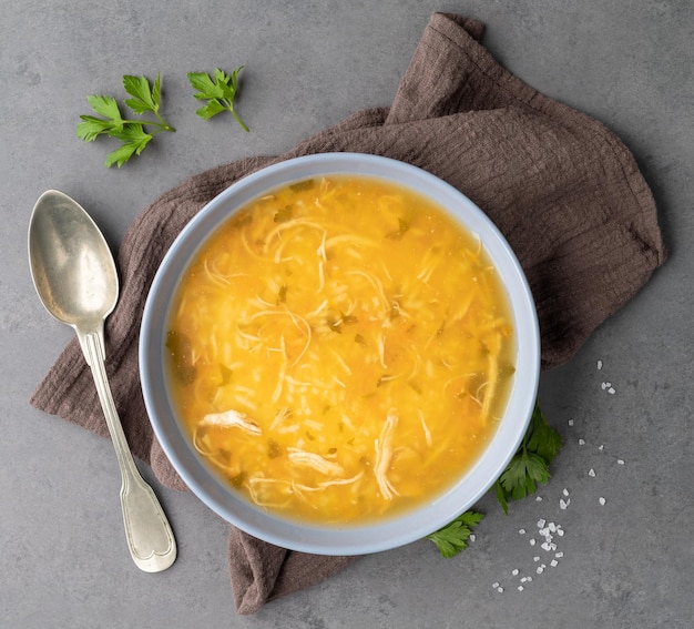 Chicken soup in a bowl over stone background