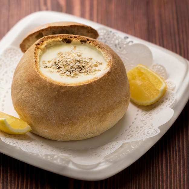 Chicken soup with oats and lemon slice served in bowl isolated on table top view soup