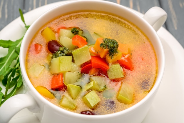 Chicken soup with vegetables. On wooden table