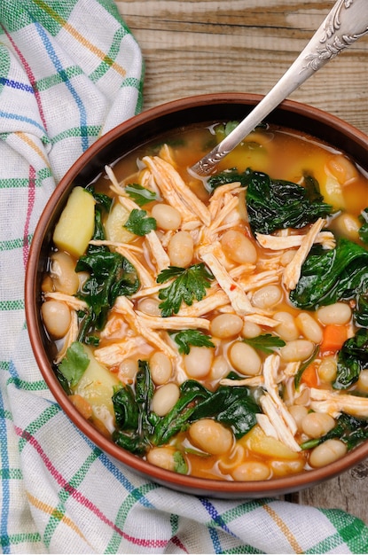 Chicken soup with white beans, spinach and tomato