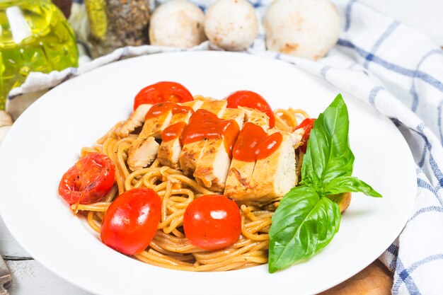 Pasta degli spaghetti del pollo sopra fondo di legno bianco con, alimento italiano.