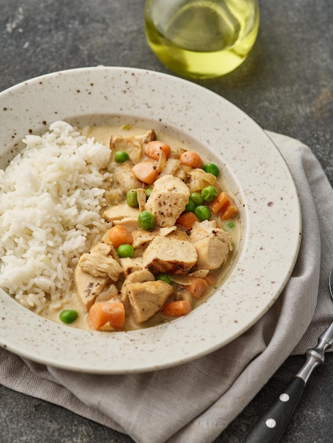 Chicken stew with vegetables and mushroom cream sauce Tender chicken fillet in a creamy mushroom sauce with rice and green peas