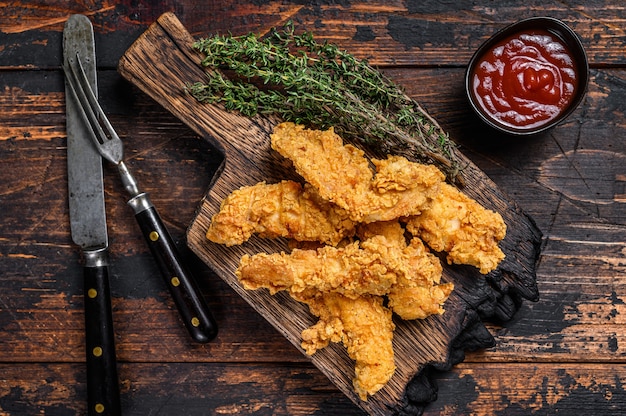 Chicken strips on a wooden cutting Board