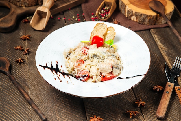 Chicken tagliatelle with mushrooms on the wooden table