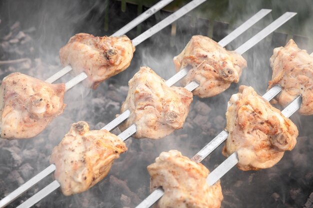 Photo chicken thighs are grilled in a brazier outside