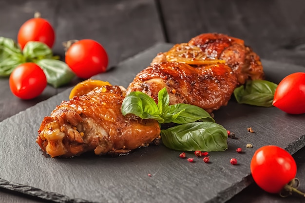 Photo chicken thighs and basil on a black table