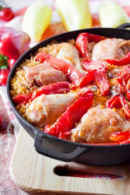 Chicken thighs and legs baked over a bed of rice and red bell pepper in cast iron stewpan