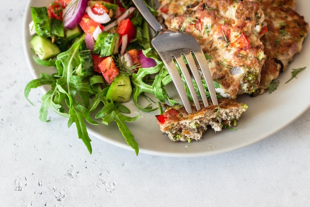 Chicken or turkey cutlets with vegetables and sauce on a plate. 