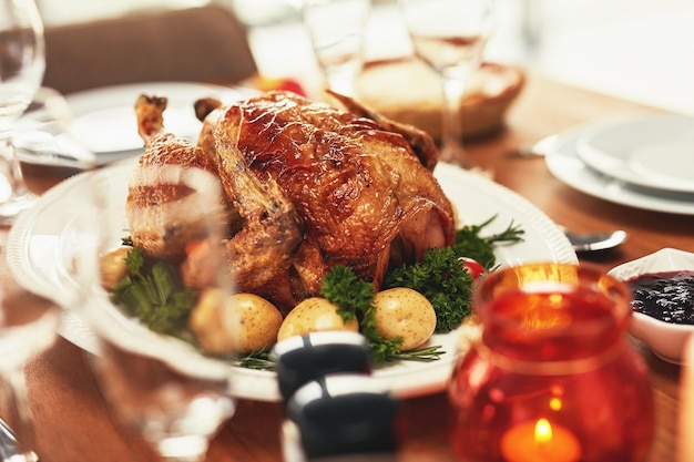 写真 家族の家でのクリスマスや感謝祭のお祝いに、家のダイニングルームのテーブルでのディナーパーティーで祝うために、バーベキューとグリルチキンの食事で、フードプレートに鶏肉の七面鳥またはバーベキュー肉
