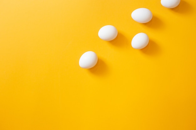 Chicken white eggs on a yellow background