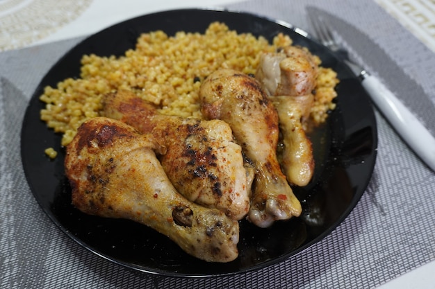 Chicken wings with couscous on black plate