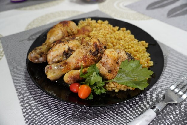 Chicken wings with couscous on black plate