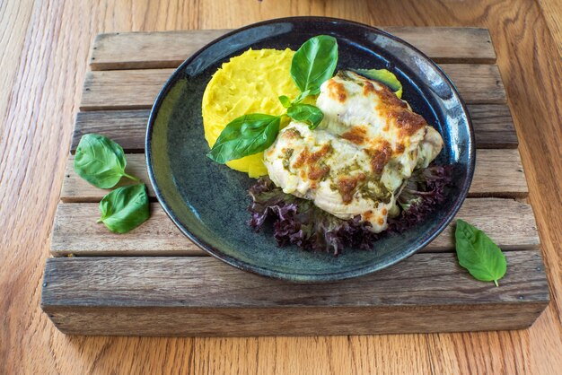 Pollo con purè di patate e salsa su legno