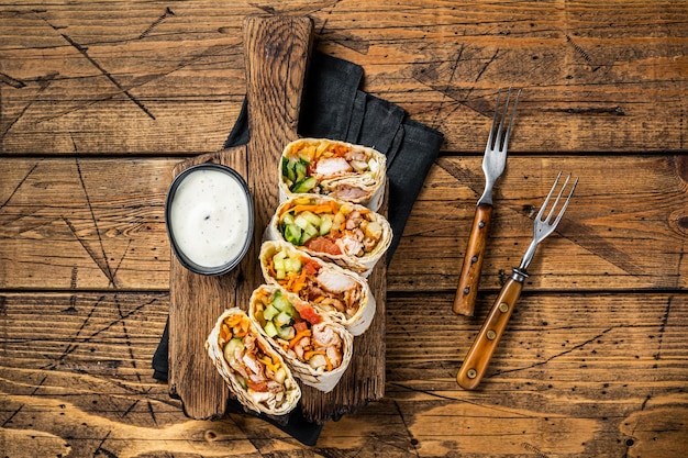 Photo chicken wrap roll durum doner kebab with meat and vegetable salad wooden background top view