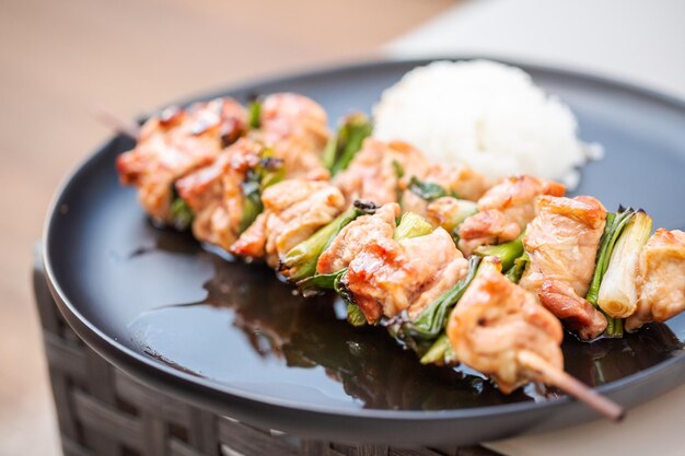 Chicken yakitori with white rice on a plate.