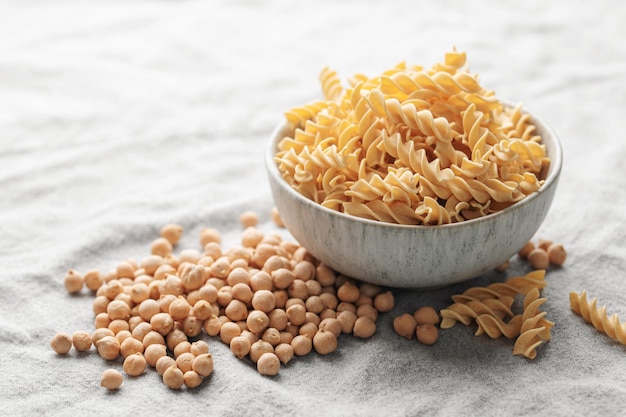 Chickpea bean fusilli pasta on a gray textile background